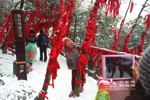 鬼谷棧道上掛滿祈愿帶的“紅樹林”在白雪中分外妖嬈，吸引游人拍照 丁云娟攝_副本.jpg