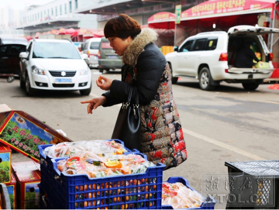 湘潭金陽城散貨區(qū)里，一位大姐正在試吃沙糖桔（記者 李蓓 攝）